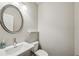 Stylish powder room showcasing a sink with oval mirror, with a toilet and a small shelf on the wall at 2817 White Oak Ln, Decatur, GA 30032