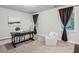 Neutral bedroom with carpet, featuring a desk, modern armchair, and windows with dark curtains at 2817 White Oak Ln, Decatur, GA 30032