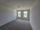 Bright bedroom features plush carpet, two windows and ample natural light, new construction at 702 Bristol Dr, Loganville, GA 30052