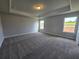 Large bedroom featuring carpet, neutral paint, tray ceiling and natural light at 702 Bristol Dr, Loganville, GA 30052