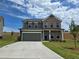 Two-story home featuring a brick and siding facade, two-car garage and concrete driveway at 702 Bristol Dr, Loganville, GA 30052