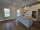 Bright kitchen featuring an island, stainless steel sink, and white cabinets at 702 Bristol Dr, Loganville, GA 30052