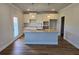 Kitchen with granite countertops, an island, pendant lighting, white cabinets, and stainless-steel sink at 702 Bristol Dr, Loganville, GA 30052
