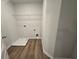 Convenient laundry room with wood-look floors, a utility sink, and washer/dryer hookups at 702 Bristol Dr, Loganville, GA 30052