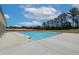 Community swimming pool surrounded by concrete patio with railings and mature trees at 702 Bristol Dr, Loganville, GA 30052