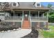 Inviting covered front porch with brick lattice and wooden stairs at 1235 Waterwood Dr, Loganville, GA 30052