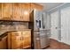 Well-organized kitchen with stainless steel refrigerator and honey-colored wooden cabinets at 1235 Waterwood Dr, Loganville, GA 30052