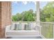 Cozy porch swing adorned with pillows, offering a peaceful spot with a scenic view of the surrounding greenery at 3718 Lake Vis, Douglasville, GA 30135