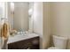Elegant powder room featuring a dark wood vanity, white countertop, decorative sconces and a toilet at 3718 Lake Vis, Douglasville, GA 30135