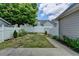 Backyard with white fence, small garden area, grass, and concrete patio at 595 Stonepark Ln, Suwanee, GA 30024