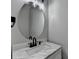Elegant powder room featuring a modern vanity with marble countertop and an oval mirror at 595 Stonepark Ln, Suwanee, GA 30024