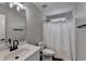 Bathroom with a single sink vanity and a toilet next to a tub with a shower curtain at 595 Stonepark Ln, Suwanee, GA 30024