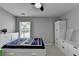 Neutral bedroom with storage dresser, ceiling fan, and natural light at 595 Stonepark Ln, Suwanee, GA 30024