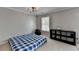 Bedroom featuring a cozy setup with a blue bed, a storage unit, and natural light from the window at 595 Stonepark Ln, Suwanee, GA 30024