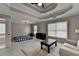 Spacious bedroom featuring a tray ceiling, carpeted floor, and ample natural light from windows at 595 Stonepark Ln, Suwanee, GA 30024