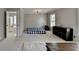 Bedroom with a view to a bathroom, a blue bed, and a black cabinet near a window at 595 Stonepark Ln, Suwanee, GA 30024