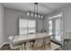 Light-filled dining area boasts stylish lighting, a view to the backyard, and modern décor at 595 Stonepark Ln, Suwanee, GA 30024