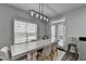 Light-filled dining area boasts stylish lighting, a view to the backyard, and modern décor at 595 Stonepark Ln, Suwanee, GA 30024