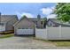 Rear exterior featuring a 2-car garage, gray siding, and white privacy fence at 595 Stonepark Ln, Suwanee, GA 30024