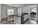 Bright kitchen features a black countertop island with dining area and stainless-steel appliances at 595 Stonepark Ln, Suwanee, GA 30024