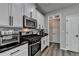 Modern kitchen with white cabinets, stainless steel appliances, and black hardware accents at 595 Stonepark Ln, Suwanee, GA 30024