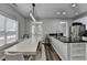 Bright kitchen features a black countertop island, a table, and stainless-steel appliances at 595 Stonepark Ln, Suwanee, GA 30024