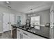 Bright kitchen features a black countertop island with stainless-steel appliances at 595 Stonepark Ln, Suwanee, GA 30024