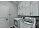 Well-organized laundry room with white cabinets, washer, and dryer for convenience at 595 Stonepark Ln, Suwanee, GA 30024