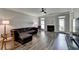 Spacious living room with fireplace, dark leather sofa, ceiling fan and luxury plank flooring at 595 Stonepark Ln, Suwanee, GA 30024
