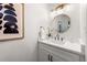 Stylish half bathroom with modern vanity, round mirror, and elegant lighting fixtures at 893 Vistavia Cir, Decatur, GA 30033