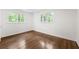 Bright bedroom featuring hardwood floors, two windows, and crisp white walls at 893 Vistavia Cir, Decatur, GA 30033