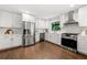 Modern white kitchen featuring stainless steel appliances, sleek countertops, and hardwood floors at 893 Vistavia Cir, Decatur, GA 30033