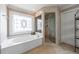 Spa-like bathroom showcasing a soaking tub, walk-in shower, and decorative window at 1021 Oakpointe Pl, Dunwoody, GA 30338