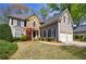 Charming two-story home featuring a stone facade, manicured lawn, and a two-car garage at 1021 Oakpointe Pl, Dunwoody, GA 30338