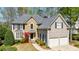 Charming two-story home with a stone and siding exterior, well-manicured landscaping, and a two-car garage at 1021 Oakpointe Pl, Dunwoody, GA 30338