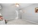 Bright bedroom featuring light gray walls, plush carpet, and a lighted ceiling fan at 1850 Linnet Ne Ct, Roswell, GA 30075