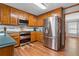Kitchen featuring stainless appliances and hardwood floors, breakfast area beyond at 1850 Linnet Ne Ct, Roswell, GA 30075