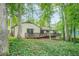 A serene backyard features a wooden deck, lush greenery, and mature trees, creating a peaceful outdoor retreat at 2174 Kinridge Rd, Marietta, GA 30062