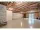 Unfinished basement with stone fireplace, exposed ceiling, painted floor, and sliding glass doors to the outdoors at 2174 Kinridge Rd, Marietta, GA 30062