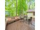 Outdoor dining set on a spacious wood deck, surrounded by the beauty of a wooded landscape at 2174 Kinridge Rd, Marietta, GA 30062