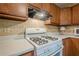 Close up of a gas range stove with white countertops and wood cabinets at 2174 Kinridge Rd, Marietta, GA 30062