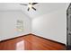 A bright bedroom features hardwood floors, a ceiling fan, and a window providing ample natural light at 3020 River Oak Mews, Decatur, GA 30034