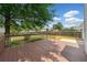 View of a spacious backyard deck and concrete patio with a mature tree providing ample shade at 3020 River Oak Mews, Decatur, GA 30034