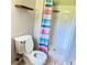 Bathroom with a toilet and a shower enclosed by a colorful striped curtain at 401 Mount Tabor Church Rd, Dallas, GA 30157