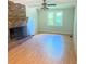 Bright living room with large brick fireplace, ceiling fan, and hardwood floors at 401 Mount Tabor Church Rd, Dallas, GA 30157