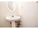 This half bathroom features a pedestal sink, oval mirror, and neutral wall color at 6540 Arbor Gate Sw Dr # 3, Mableton, GA 30126