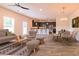 Cozy living room seamlessly connects with modern kitchen, complete with stainless steel appliances and sleek dark brown cabinetry at 1673 Fuma Leaf Way, Mcdonough, GA 30253