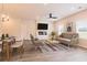 Bright living room features a large TV, a sleek ceiling fan, and an open floorplan that connects seamlessly with the dining area at 1673 Fuma Leaf Way, Mcdonough, GA 30253
