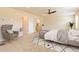 A spacious and cozy main bedroom features a ceiling fan, and is furnished with a comfortable armchair and stylish decor at 1673 Fuma Leaf Way, Mcdonough, GA 30253