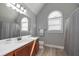 Bright bathroom featuring a wood vanity, gray walls, and arched window at 9001 E Carroll Rd, Winston, GA 30187